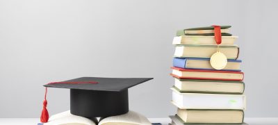 front-view-stacked-books-graduation-cap-open-book-education-day
